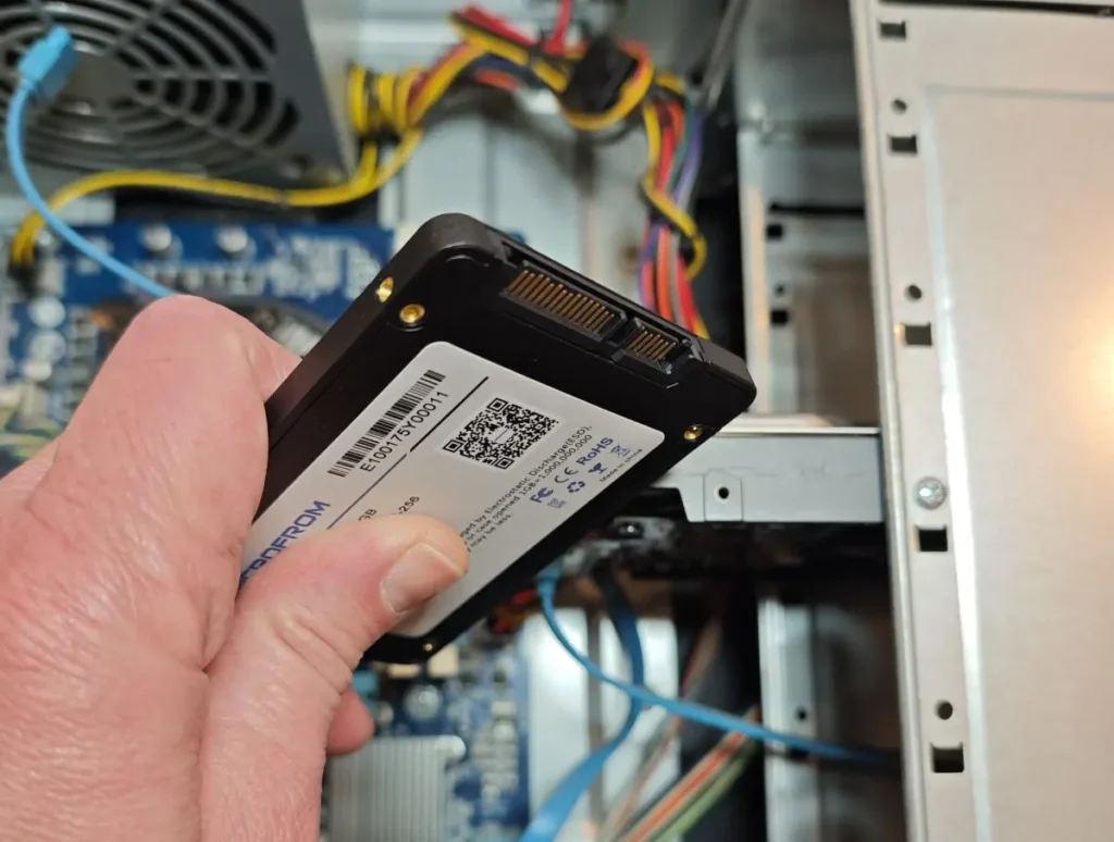 Serviser računara drži SSD pre ugradnje i dijagnostike u desktop kućište