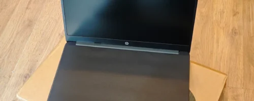 Potpuno nov HP laptop poluotvoren na originalnoj kartonskoj ambalaži sa zaštitnim papirom preko tastature pre prve upotrebe
