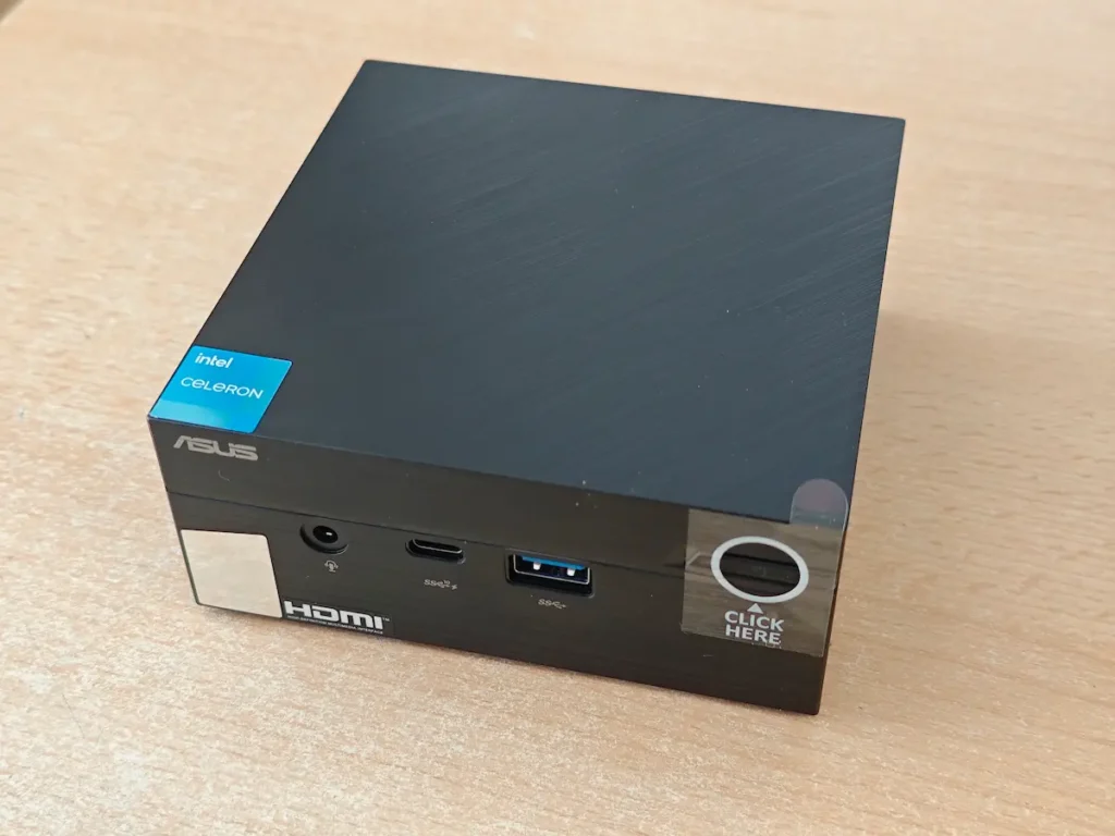 Asus Mini PC računar sa Celeron procesorom na radnom stolu.