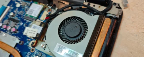 Otvoren laptop pogled na ventilator i matičnu ploču prilikom zamene konektora